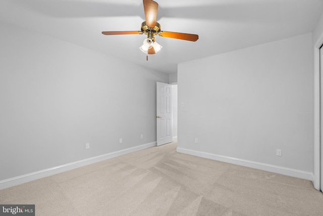 empty room featuring light colored carpet and ceiling fan