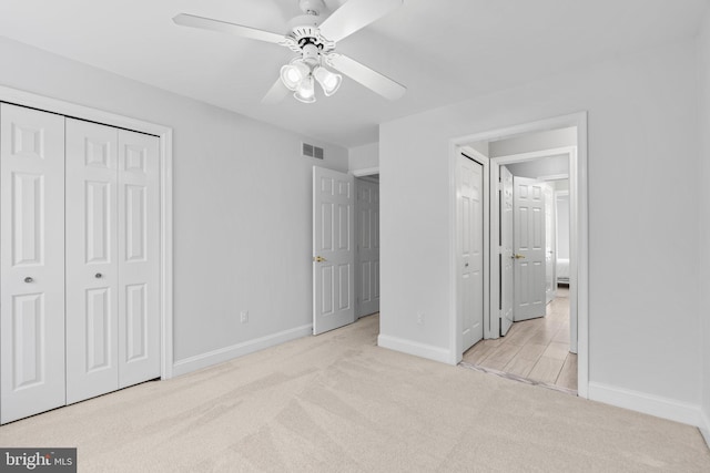 unfurnished bedroom with light carpet, ceiling fan, and a closet