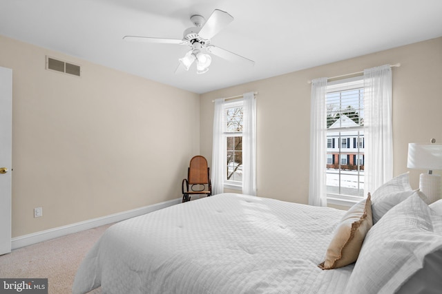 carpeted bedroom featuring ceiling fan and multiple windows