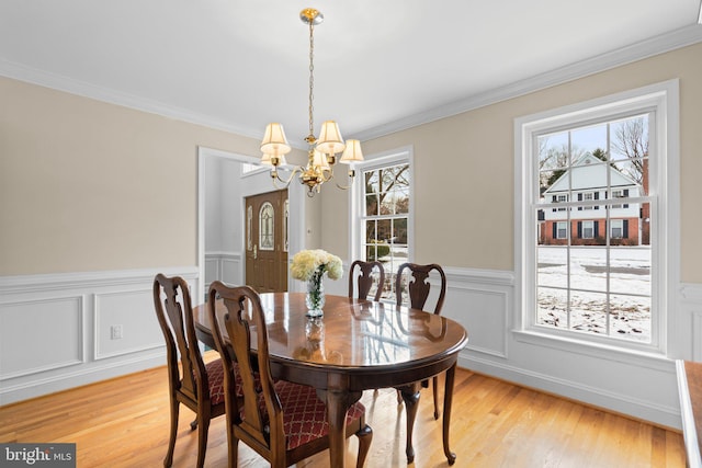 dining space featuring an inviting chandelier, a wealth of natural light, and ornamental molding