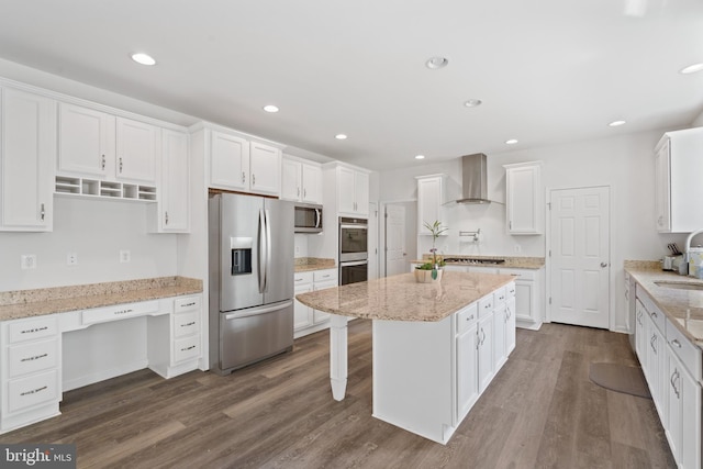 kitchen with white cabinetry, wall chimney range hood, appliances with stainless steel finishes, and dark hardwood / wood-style floors