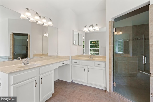 bathroom featuring a shower with door, vanity, and tile patterned flooring