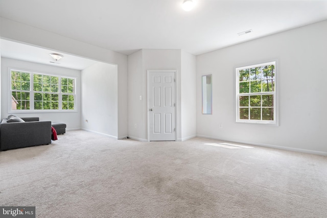 unfurnished room with light carpet and plenty of natural light