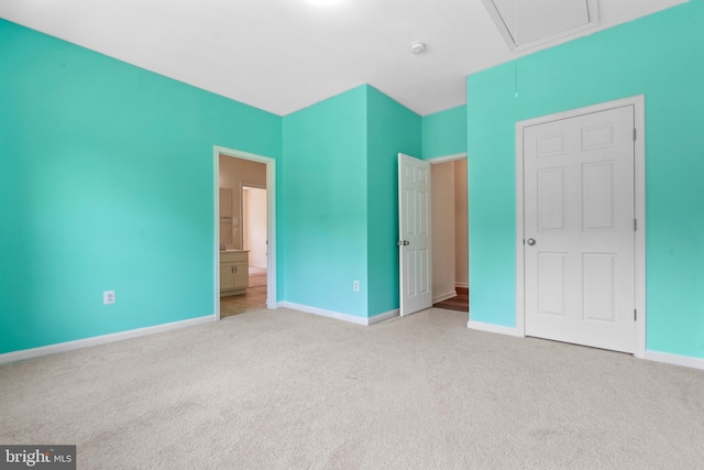 unfurnished bedroom featuring light colored carpet and connected bathroom