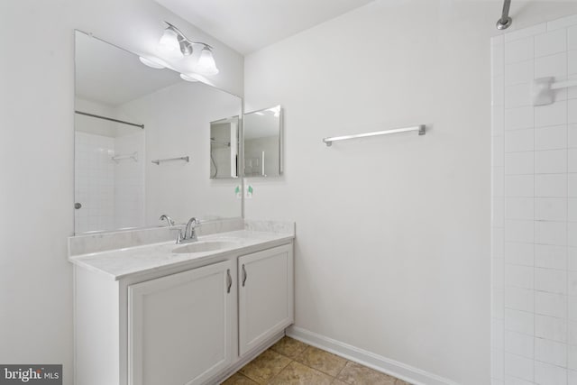 bathroom with tile patterned flooring, walk in shower, and vanity