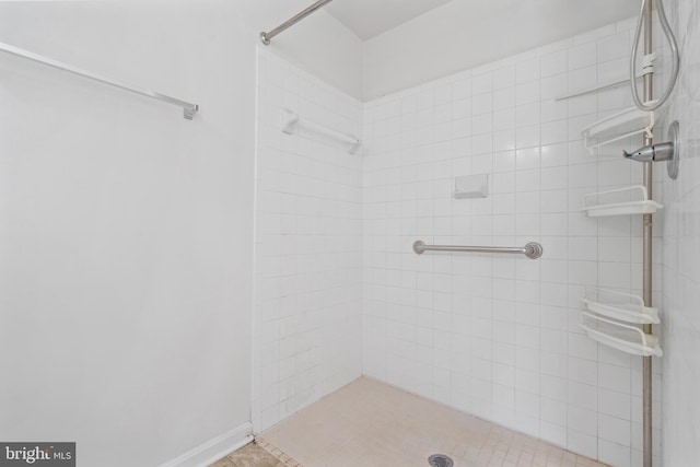 bathroom featuring a tile shower and tile patterned flooring