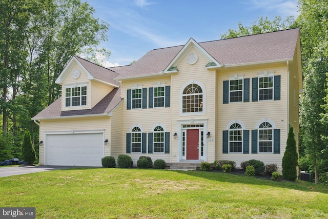 colonial inspired home featuring central AC unit, a garage, and a front lawn