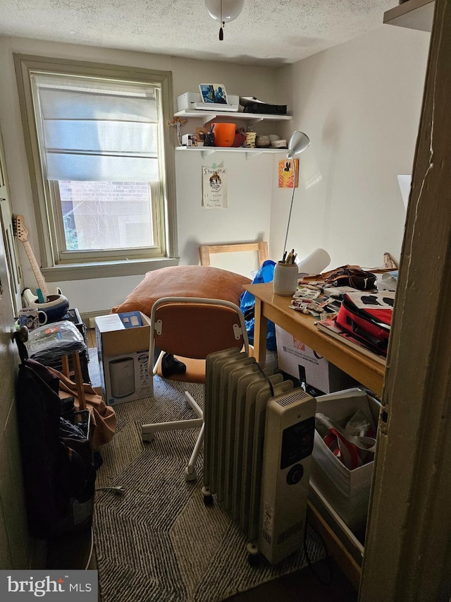 miscellaneous room featuring radiator heating unit and a textured ceiling