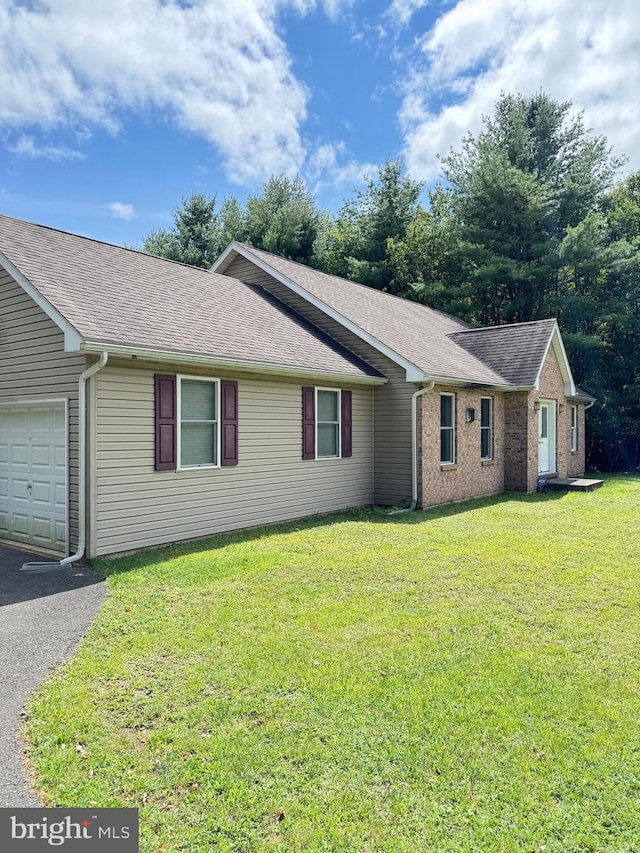 single story home with a front yard and a garage