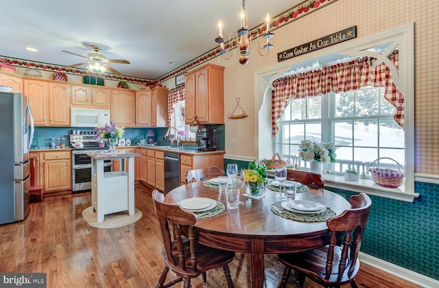 kitchen with a center island, wood-type flooring, sink, stainless steel appliances, and light brown cabinetry