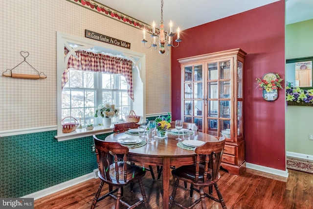 dining area with dark wood-type flooring and a notable chandelier