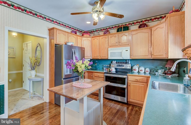 kitchen featuring stainless steel appliances, light brown cabinets, tasteful backsplash, dark hardwood / wood-style flooring, and sink