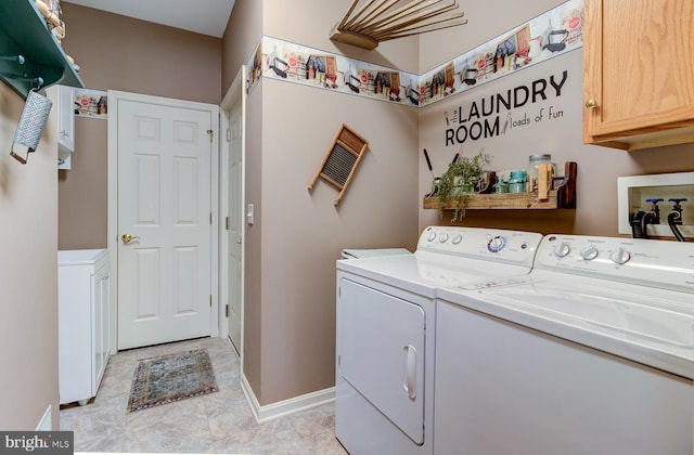 clothes washing area with cabinets and separate washer and dryer