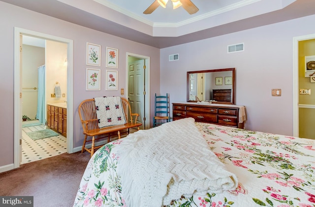 carpeted bedroom featuring ceiling fan, crown molding, a tray ceiling, and ensuite bath