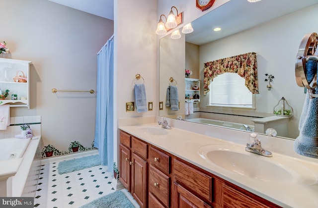 bathroom with tiled tub and vanity