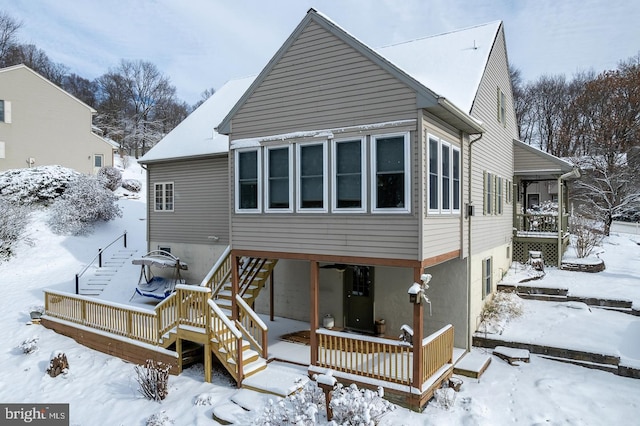 snow covered house with a wooden deck