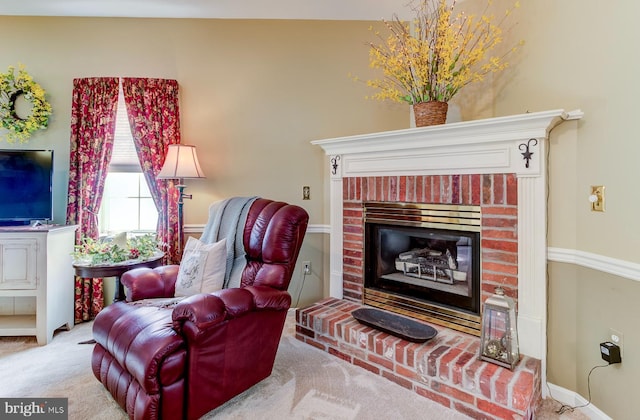 interior space with light carpet and a brick fireplace