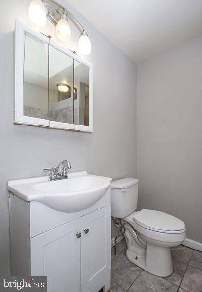 bathroom featuring vanity, toilet, and tile patterned flooring