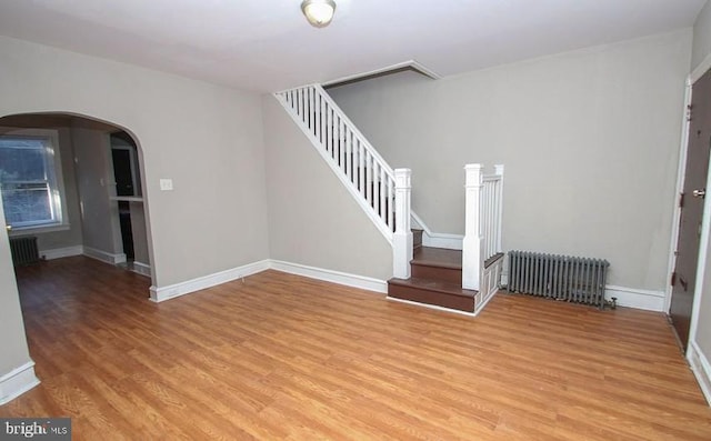 interior space featuring radiator heating unit and light hardwood / wood-style floors