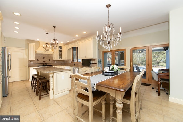 tiled dining area with french doors, a notable chandelier, and sink