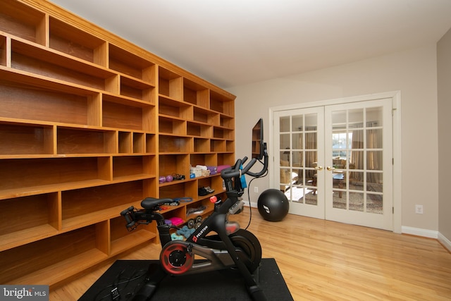 workout area with light hardwood / wood-style flooring and french doors