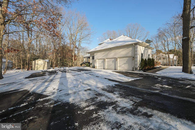 view of snowy exterior featuring a storage shed