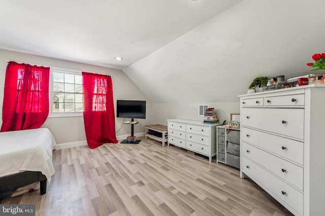 bedroom with light wood-type flooring and lofted ceiling