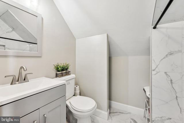 bathroom featuring toilet, vaulted ceiling, and vanity