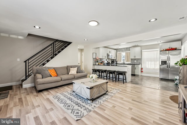 living room featuring sink and light hardwood / wood-style flooring