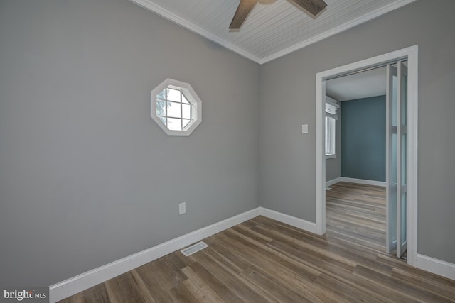 spare room featuring ceiling fan, wood-type flooring, and crown molding