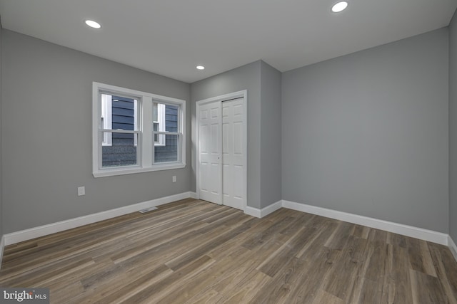 unfurnished bedroom with a closet and dark hardwood / wood-style floors