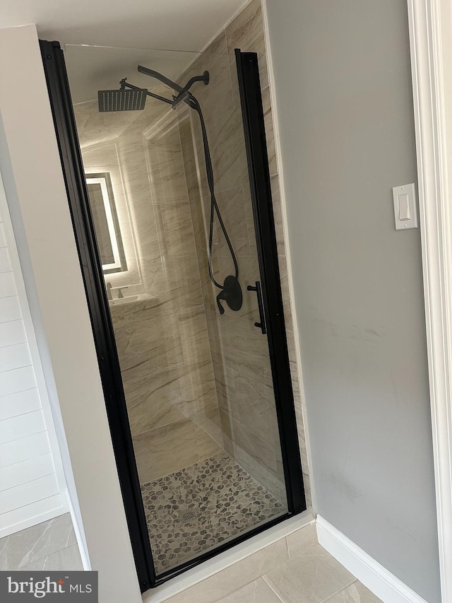 bathroom with tile patterned floors and a tile shower