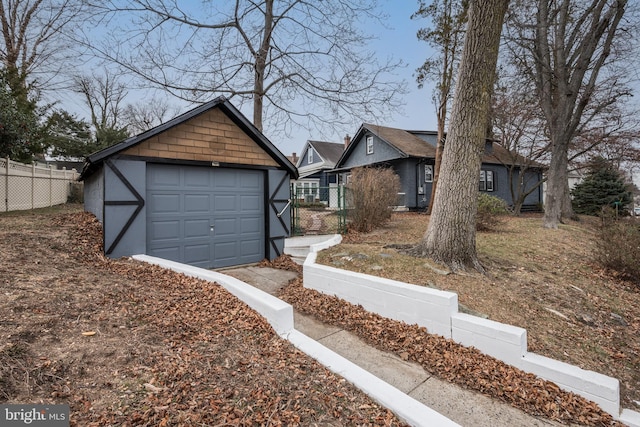 view of front of house featuring a garage and an outbuilding