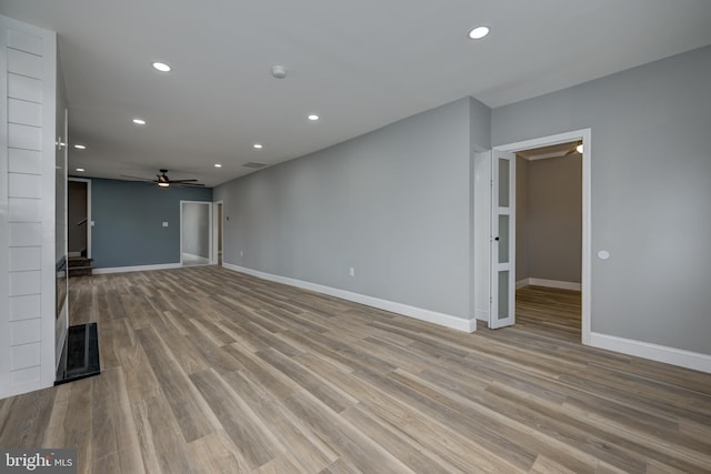 unfurnished living room with ceiling fan and light hardwood / wood-style flooring