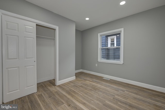 unfurnished bedroom with a closet and light hardwood / wood-style flooring