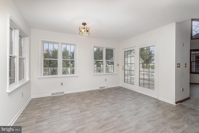 unfurnished dining area with a wealth of natural light and an inviting chandelier