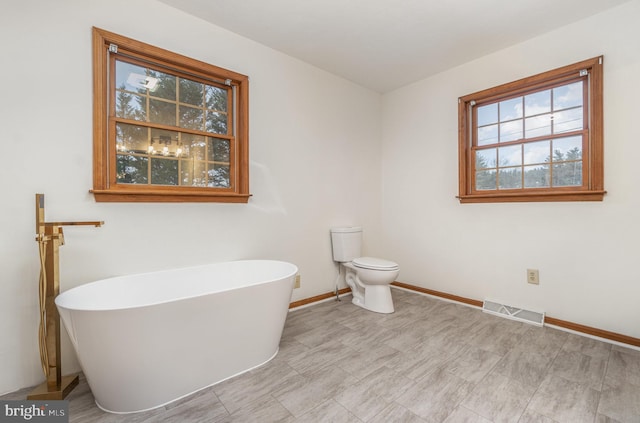 bathroom featuring toilet and a bathing tub