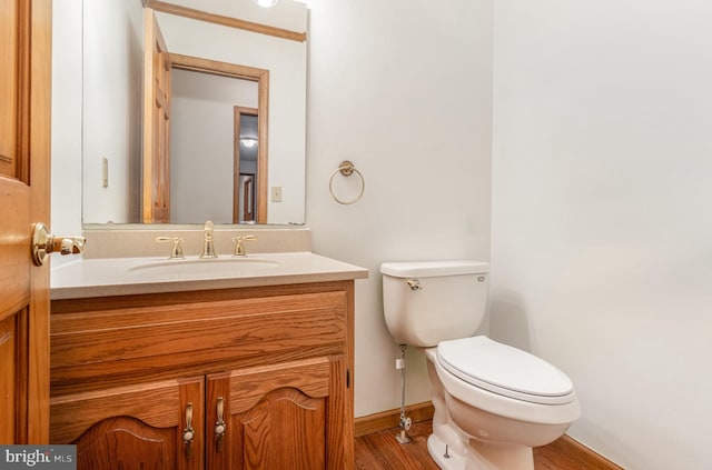 bathroom featuring toilet, vanity, and hardwood / wood-style floors