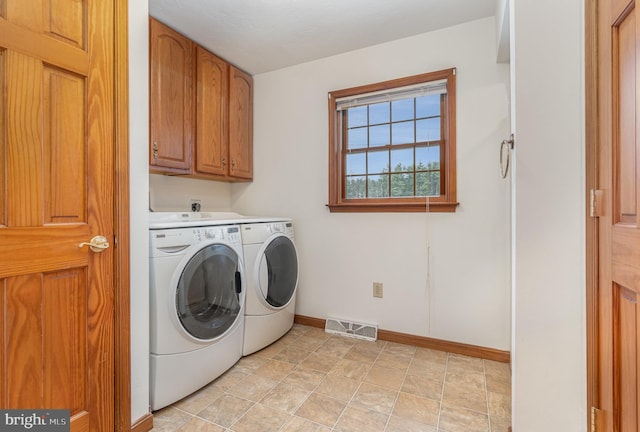 clothes washing area featuring cabinets and washing machine and clothes dryer