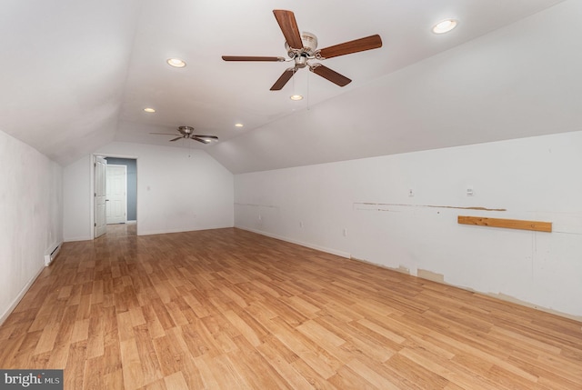 additional living space featuring lofted ceiling, baseboard heating, and light hardwood / wood-style flooring