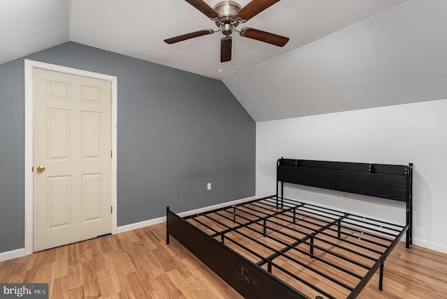 bedroom featuring ceiling fan, lofted ceiling, and light wood-type flooring