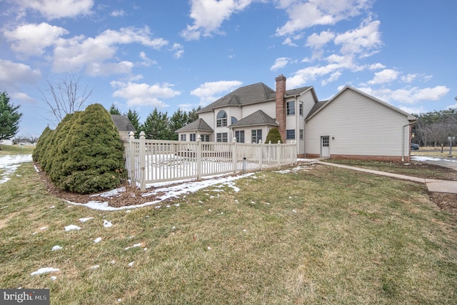 rear view of house featuring a lawn