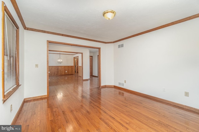 empty room featuring crown molding and light hardwood / wood-style floors