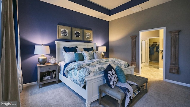 carpeted bedroom featuring a closet and a walk in closet