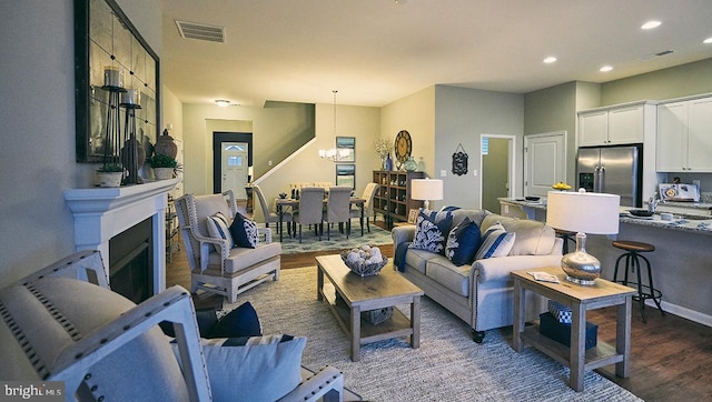 living room featuring dark hardwood / wood-style flooring and a notable chandelier