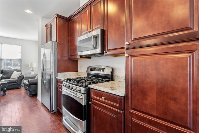 kitchen featuring light stone counters, dark wood-type flooring, and appliances with stainless steel finishes