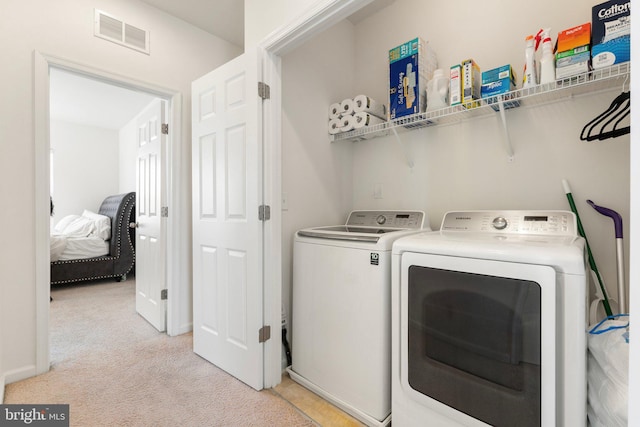 laundry area featuring light carpet and washing machine and dryer