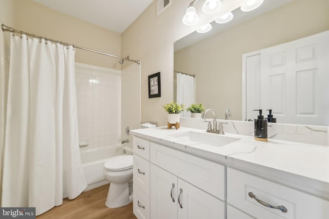 full bathroom featuring vanity, hardwood / wood-style floors, toilet, and shower / bath combo with shower curtain