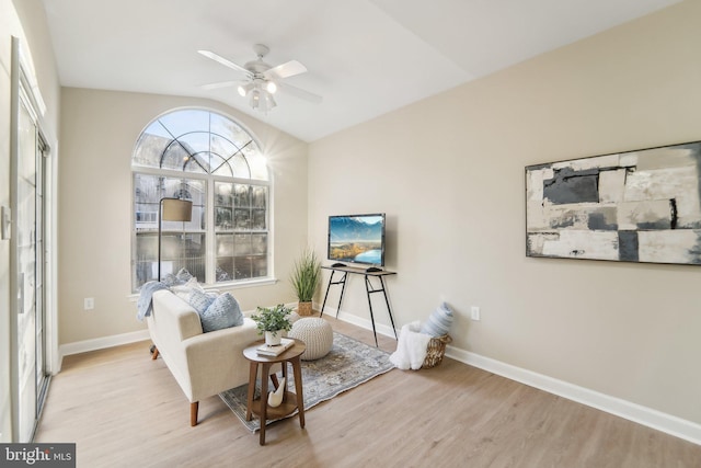 living area featuring ceiling fan, lofted ceiling, and light hardwood / wood-style flooring