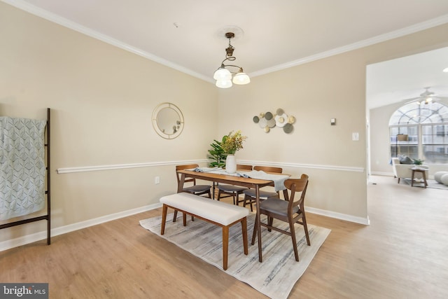 dining area featuring ornamental molding, ceiling fan with notable chandelier, and light hardwood / wood-style flooring